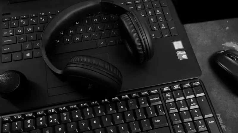 A headset resting on a desk beside a keyboard
