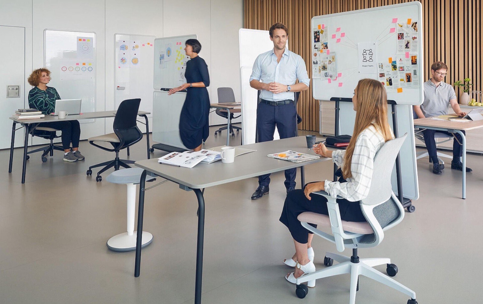 A team working at desks and a whiteboard in a bright studio